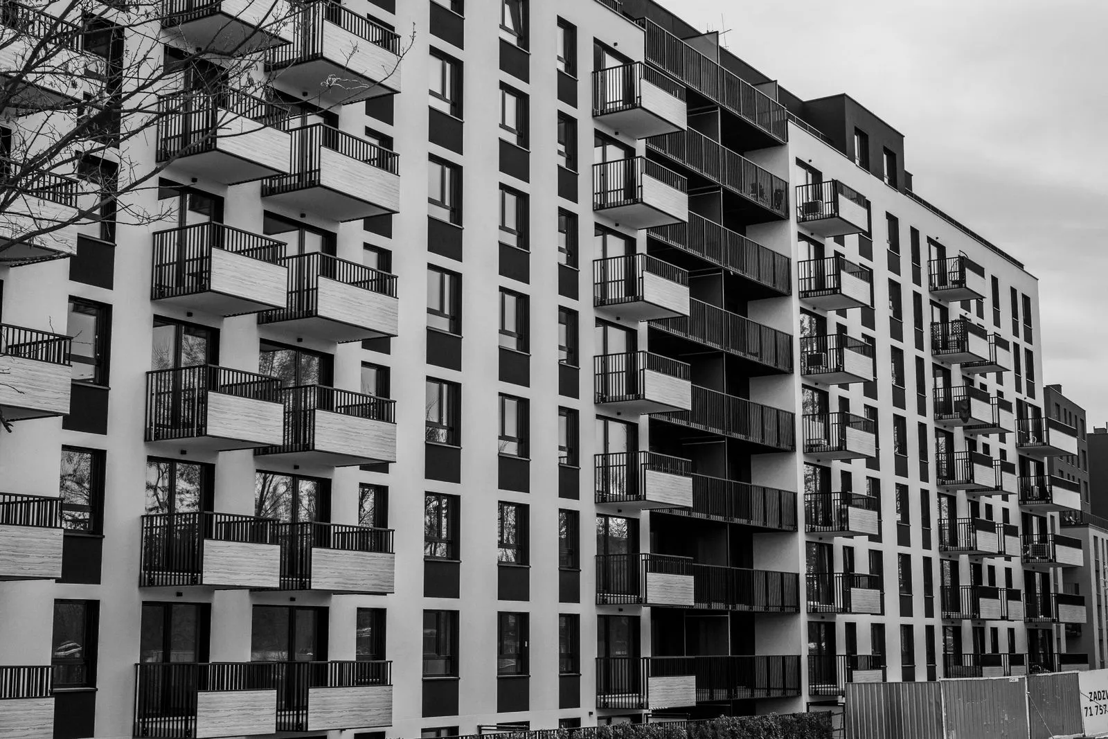 Black and white photo of a contemporary apartment building with multiple balconies.